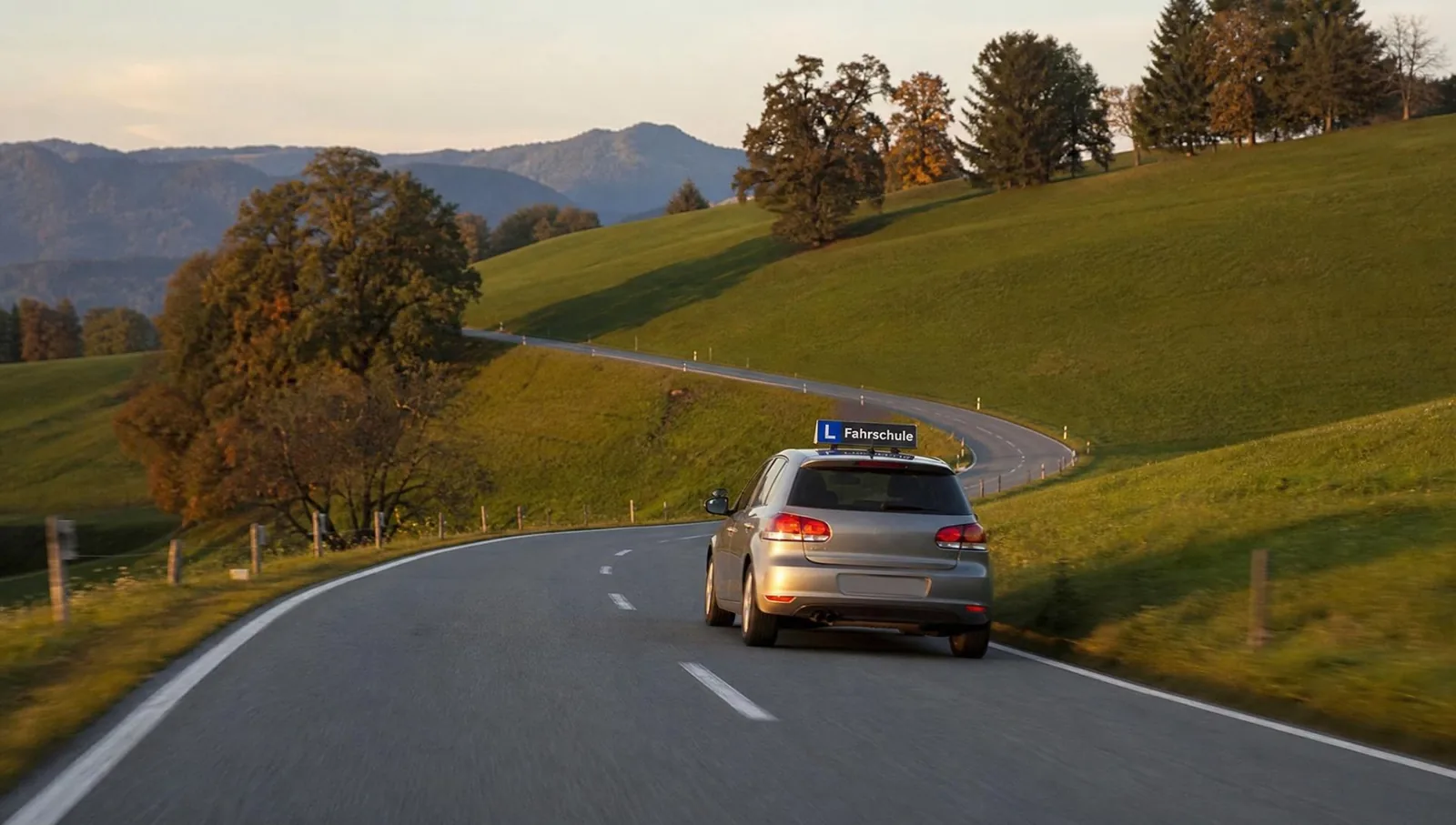 Fahrschulauto mit L-Dachschild auf einer Schweizer Landstrasse